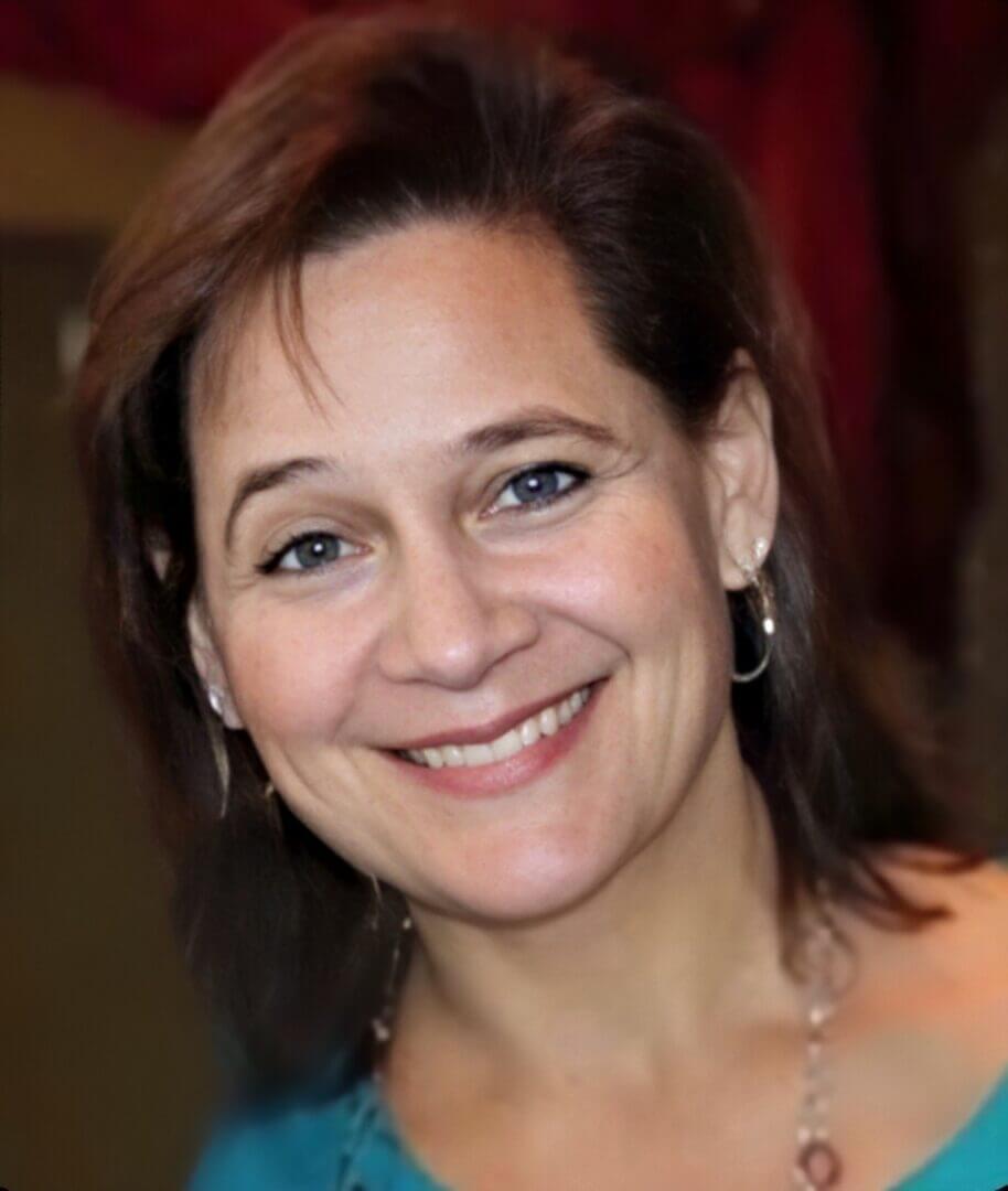 Smiling woman with brown hair and blue eyes, promoting positive work culture at Elevate Your Organization's Culture and Performance With CEEK.