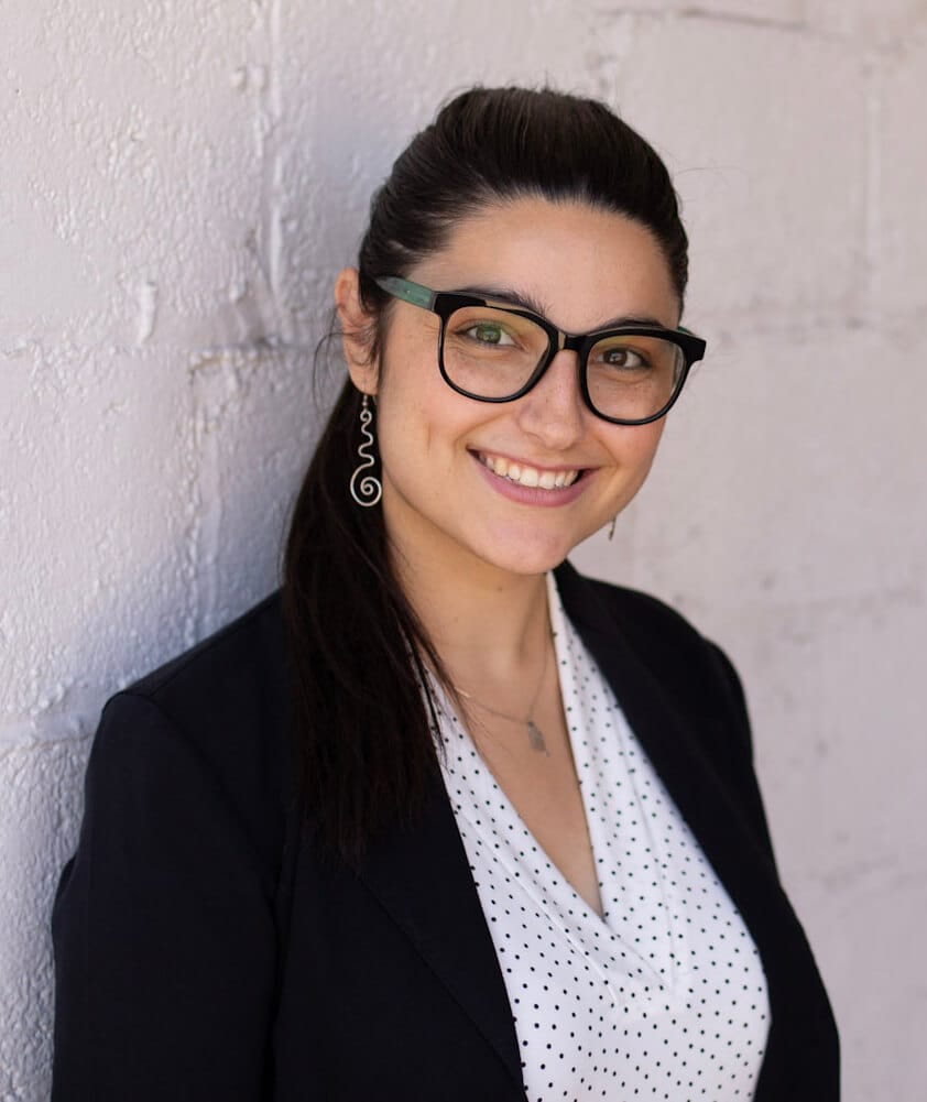 Professional woman smiling in business attire, showcasing team culture and performance strategies, only at Elevate Your Organization's Culture and Performance With CEEK.