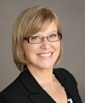 Professional woman smiling, representing Elevate Your Organization's Culture and Performance With CEEK's leadership expertise.