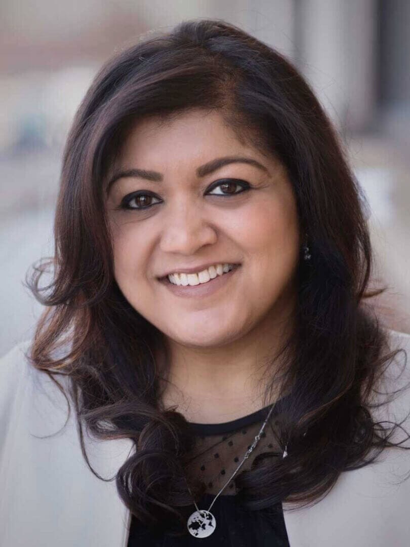 Smiling individual with dark hair, showcasing professional culture, only available at Elevate Your Organization's Culture and Performance With CEEK.