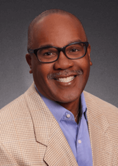 Smiling professional in a suit, part of Elevate Your Organization's Culture and Performance With CEEK's team, showcasing expertise and leadership.