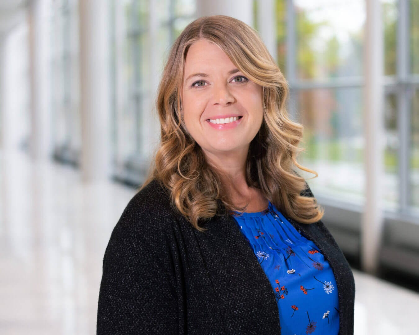 Professional portrait of a smiling woman in a blue blouse, featured at Elevate Your Organization's Culture and Performance With CEEK.
