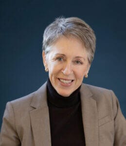 Professional portrait of a smiling woman in a blazer, available at Elevate Your Organization's Culture and Performance With CEEK.