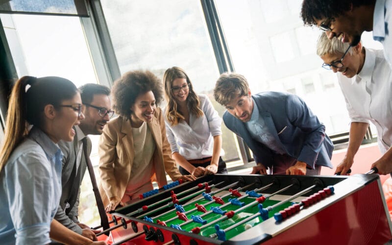 Colleagues playing table football in the break in office