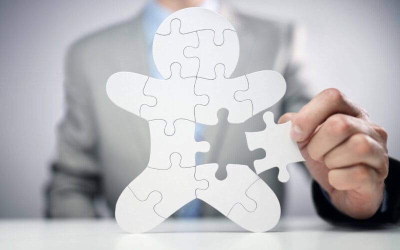 Businessman assembling jigsaw puzzle human team employee concept